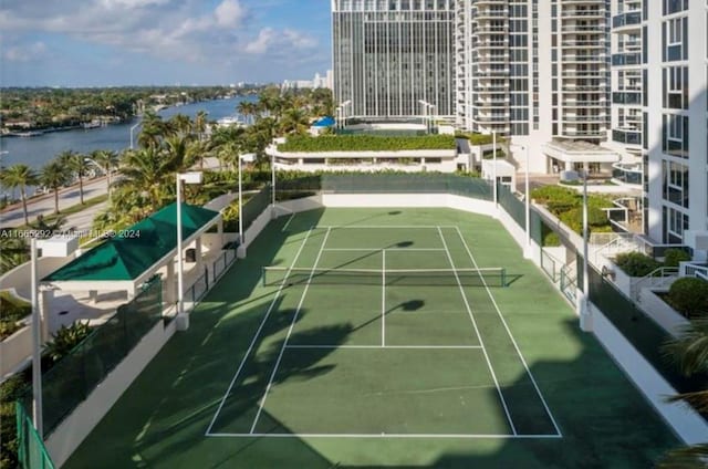 view of tennis court with a water view