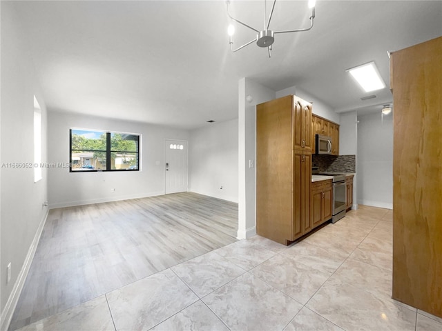 kitchen featuring backsplash, stainless steel appliances, and light hardwood / wood-style flooring