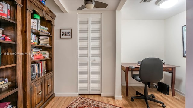 home office with light hardwood / wood-style floors and ceiling fan