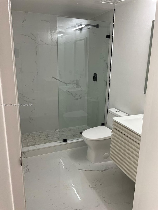 bathroom featuring vanity, toilet, and an enclosed shower