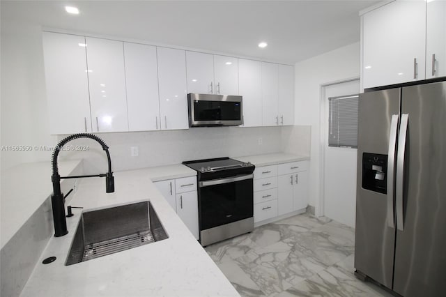 kitchen with white cabinets, appliances with stainless steel finishes, and sink