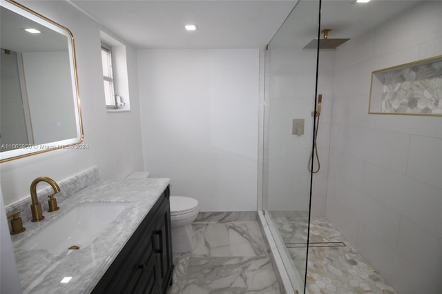 bathroom featuring a tile shower, vanity, and toilet