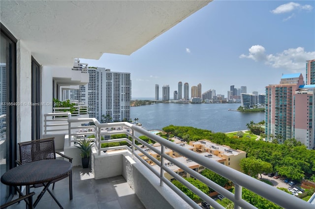 balcony with a water view and a view of city