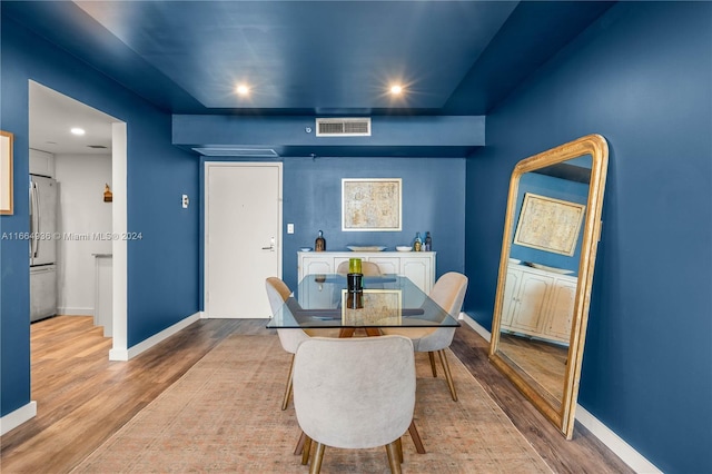 dining room featuring baseboards, wood finished floors, visible vents, and recessed lighting