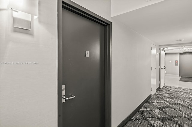 corridor with baseboards and elevator