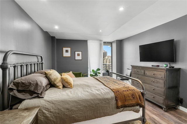 bedroom featuring baseboards, wood finished floors, and recessed lighting