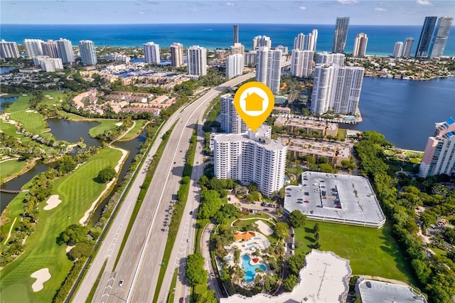 drone / aerial view with a city view, golf course view, and a water view