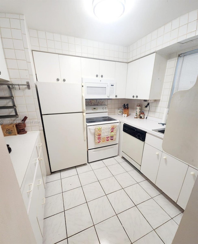 kitchen featuring white cabinets, light tile patterned flooring, white appliances, and backsplash