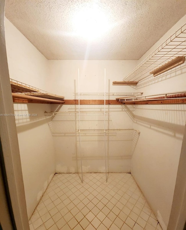 spacious closet with light tile patterned floors