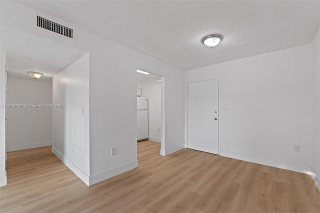 interior space with a textured ceiling and light hardwood / wood-style flooring