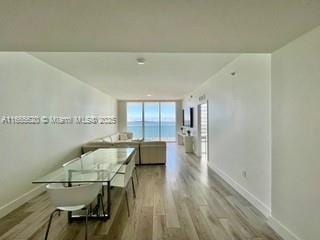 hallway featuring a water view, baseboards, and wood finished floors