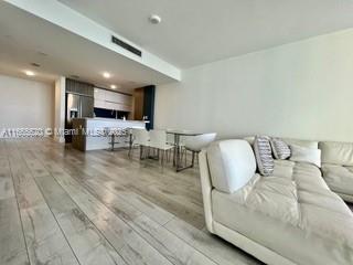 living room with light wood-style floors and visible vents