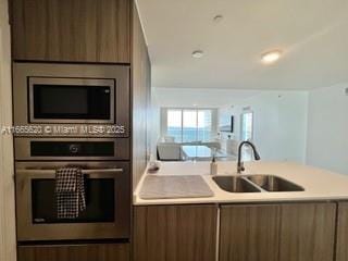 kitchen featuring a sink, stainless steel appliances, light countertops, and modern cabinets