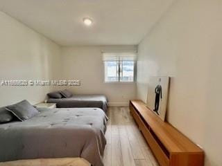 bedroom featuring baseboards and light wood finished floors
