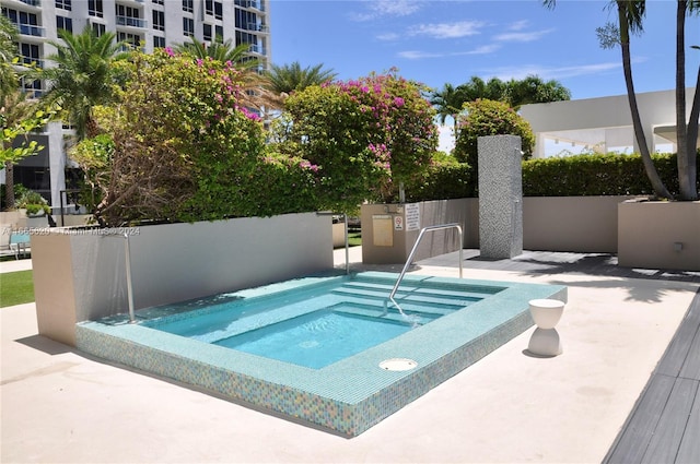 view of swimming pool with a hot tub