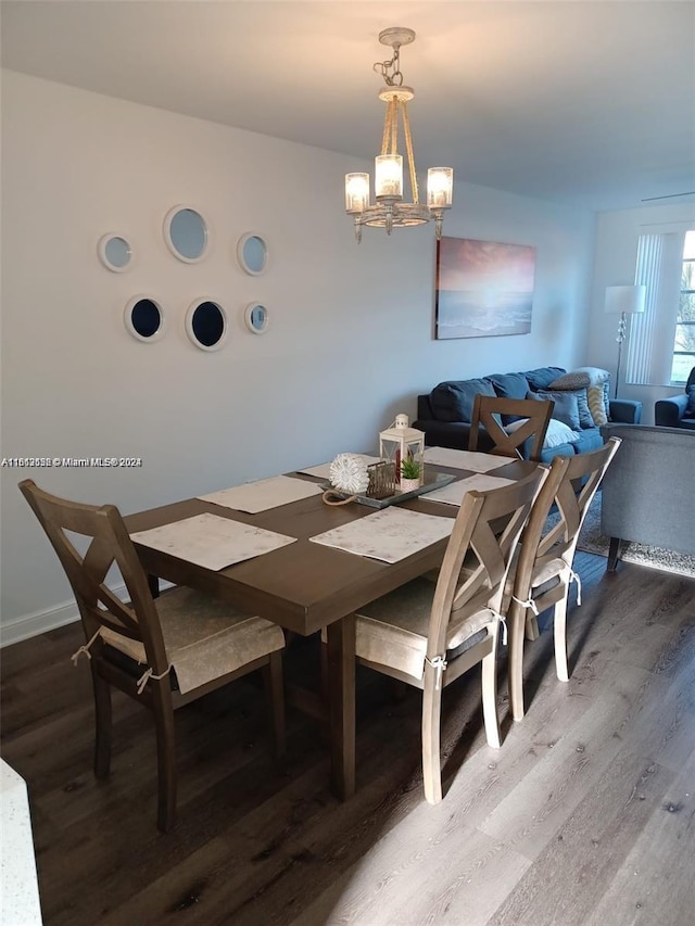 dining area featuring wood-type flooring and a chandelier