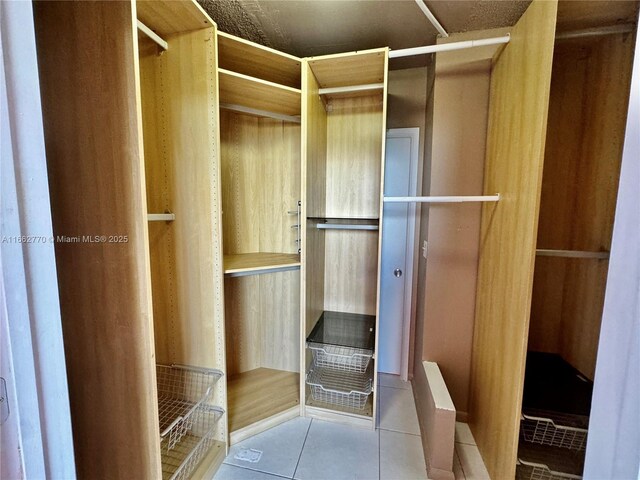 spacious closet with light tile patterned floors