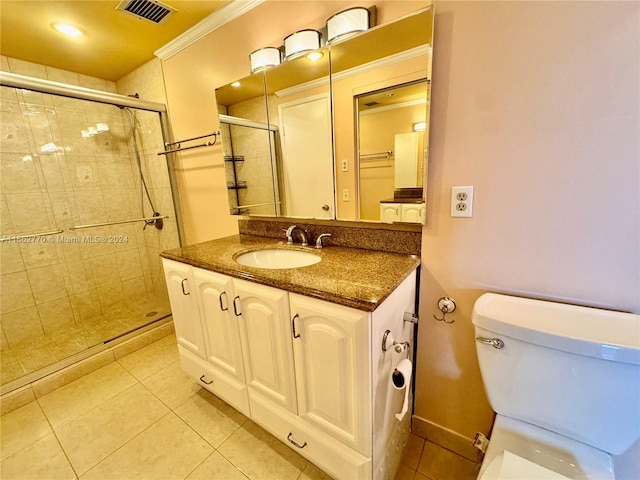 bathroom featuring crown molding, vanity, tile patterned flooring, toilet, and a shower with shower door