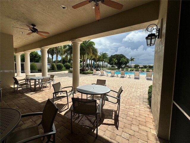 view of patio with ceiling fan and a community pool