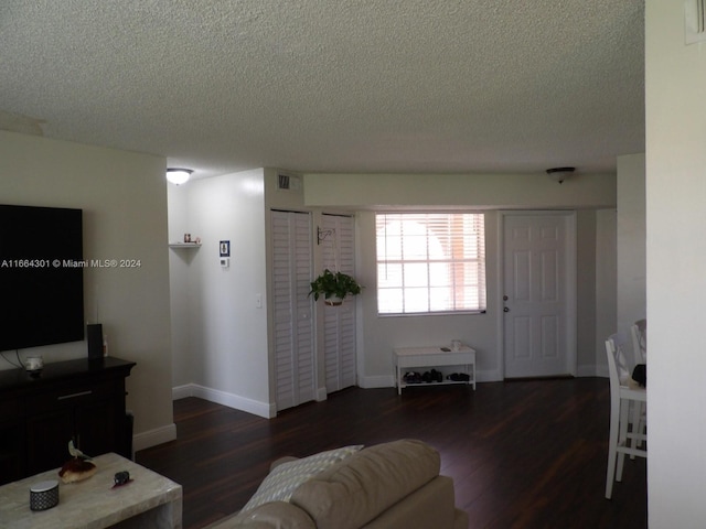 living room featuring a textured ceiling and dark hardwood / wood-style floors