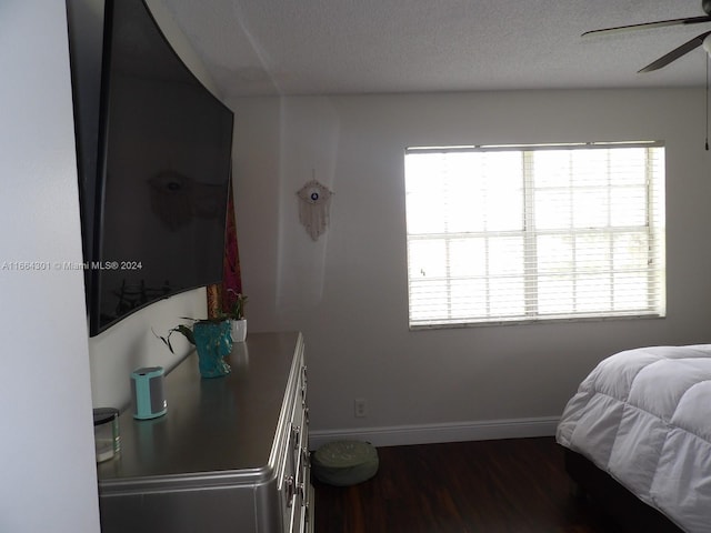 bedroom featuring ceiling fan, a textured ceiling, and wood-type flooring