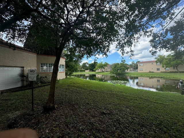 view of yard with a water view and a garage