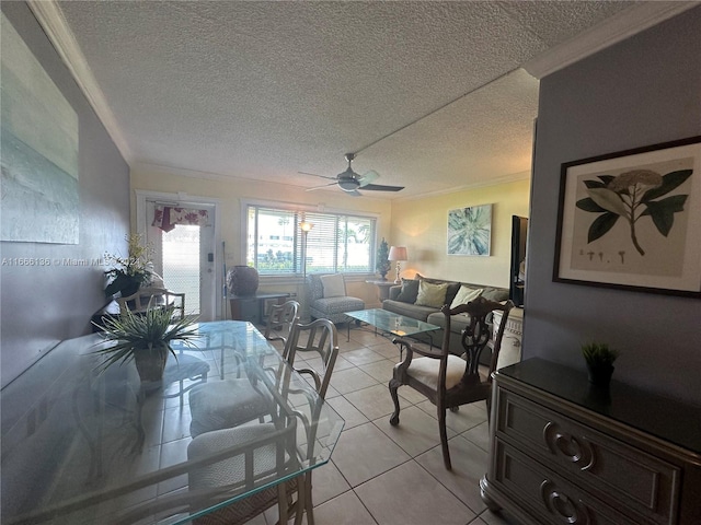 tiled dining space featuring ornamental molding, ceiling fan, and a textured ceiling