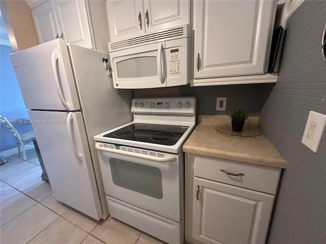 kitchen featuring white cabinets, white appliances, and light tile patterned flooring