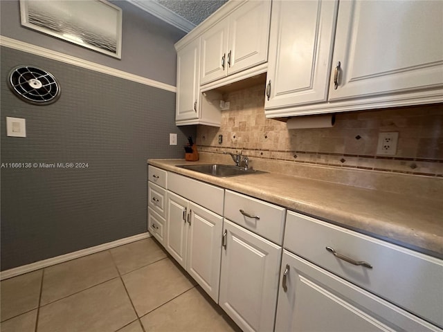 kitchen featuring light tile patterned floors, white cabinets, and sink