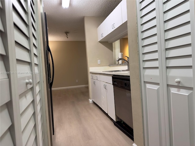 kitchen with light hardwood / wood-style floors, white cabinetry, dishwasher, a textured ceiling, and sink