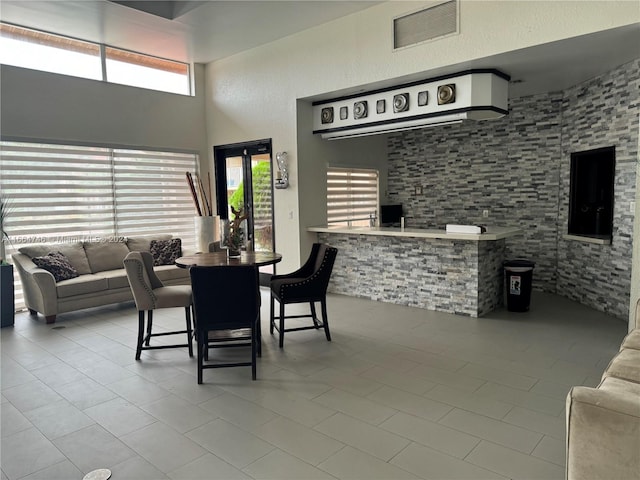 tiled dining area featuring a towering ceiling