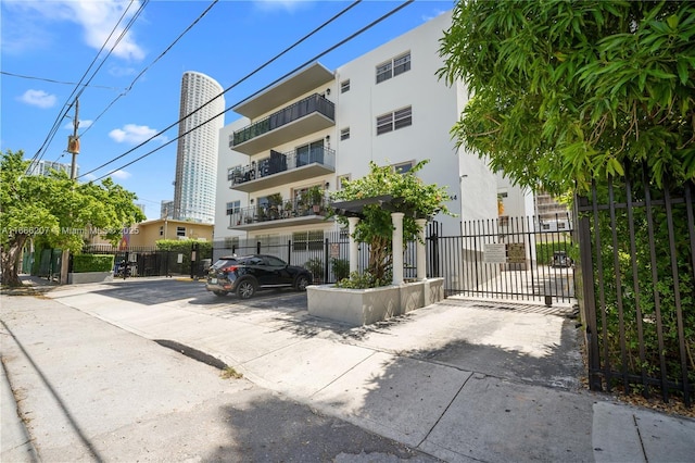 view of property featuring uncovered parking and fence