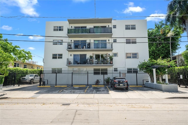 view of property featuring uncovered parking and fence