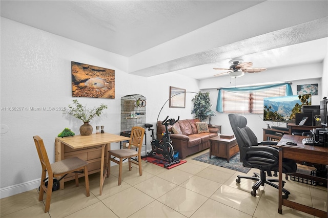 office space featuring light tile patterned floors, ceiling fan, baseboards, and a textured ceiling
