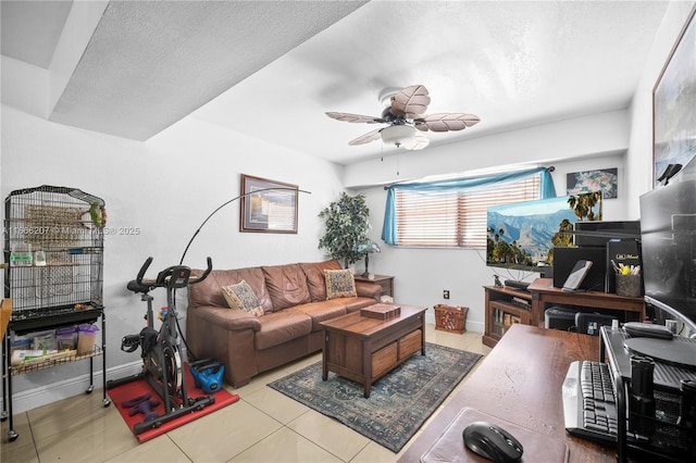 living room with ceiling fan, tile patterned flooring, baseboards, and a textured ceiling