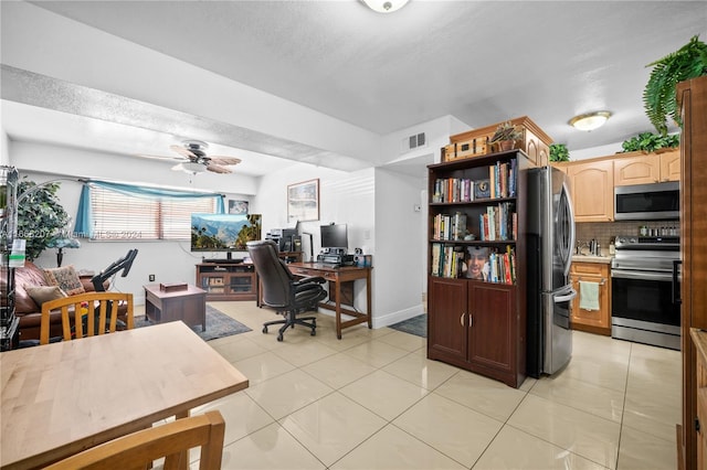 home office with light tile patterned floors and ceiling fan