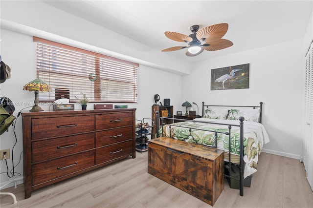 bedroom featuring light wood-style floors, ceiling fan, baseboards, and multiple windows