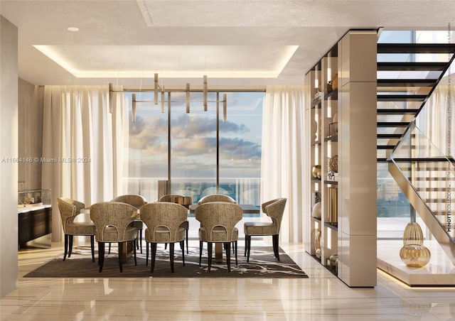 dining room featuring a healthy amount of sunlight, floor to ceiling windows, and a raised ceiling