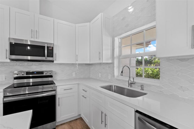 kitchen with white cabinets, stainless steel appliances, and decorative backsplash