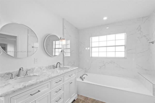 bathroom featuring a bath, wood-type flooring, and vanity