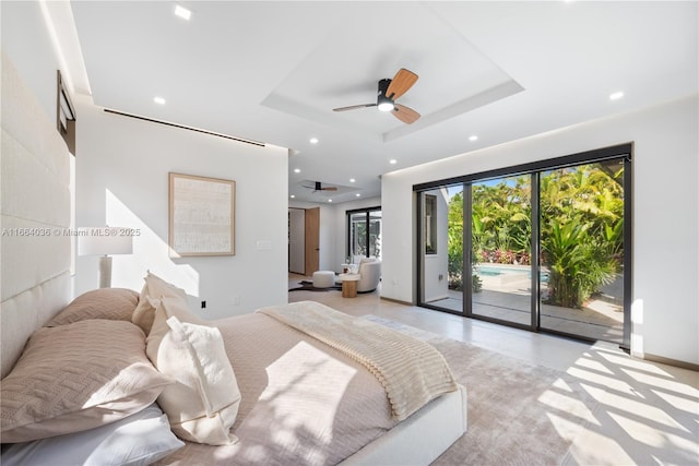 bedroom featuring a tray ceiling, access to outside, and ceiling fan