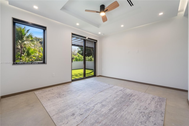 spare room featuring a raised ceiling and ceiling fan