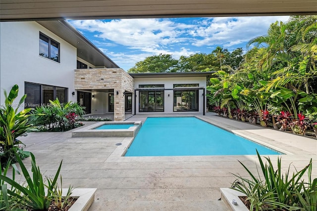 view of swimming pool with an in ground hot tub and a patio