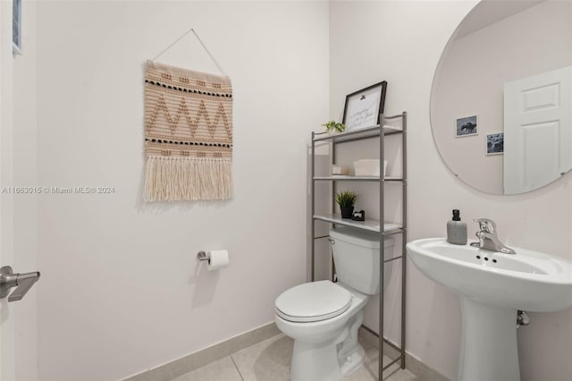 bathroom featuring toilet, sink, and tile patterned flooring