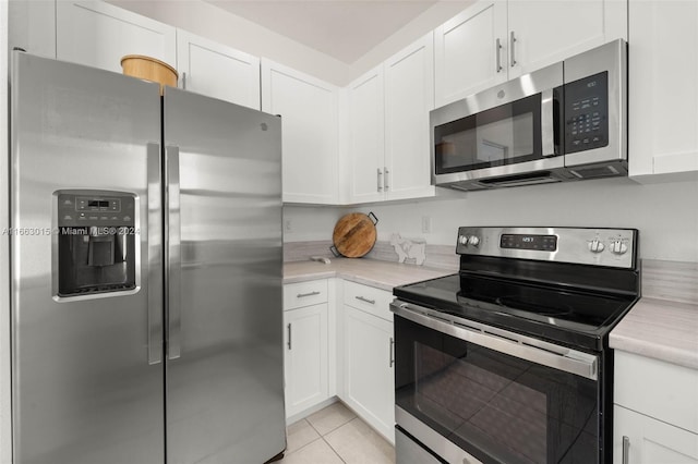 kitchen with white cabinetry, appliances with stainless steel finishes, and light tile patterned flooring