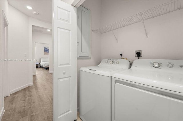 laundry room featuring washing machine and clothes dryer and light hardwood / wood-style floors