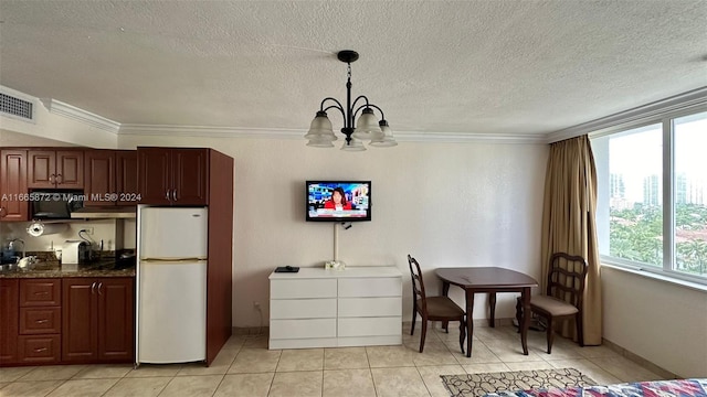 kitchen featuring white refrigerator, decorative light fixtures, plenty of natural light, and a notable chandelier