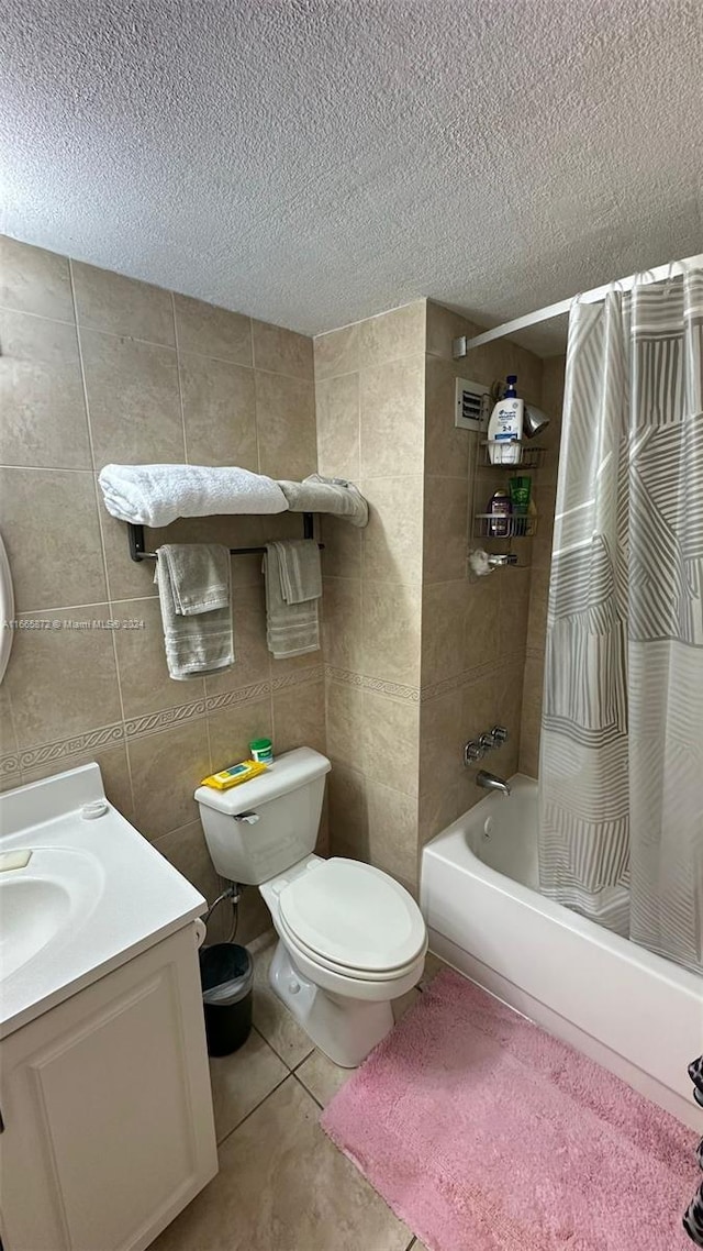 full bathroom featuring vanity, a textured ceiling, shower / bathtub combination with curtain, tile walls, and toilet