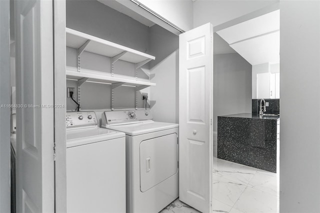 clothes washing area with washer and dryer and sink