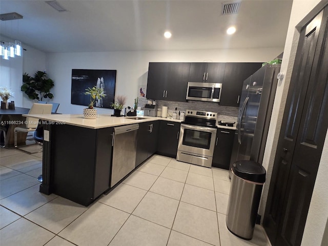 kitchen featuring sink, hanging light fixtures, stainless steel appliances, kitchen peninsula, and light tile patterned flooring